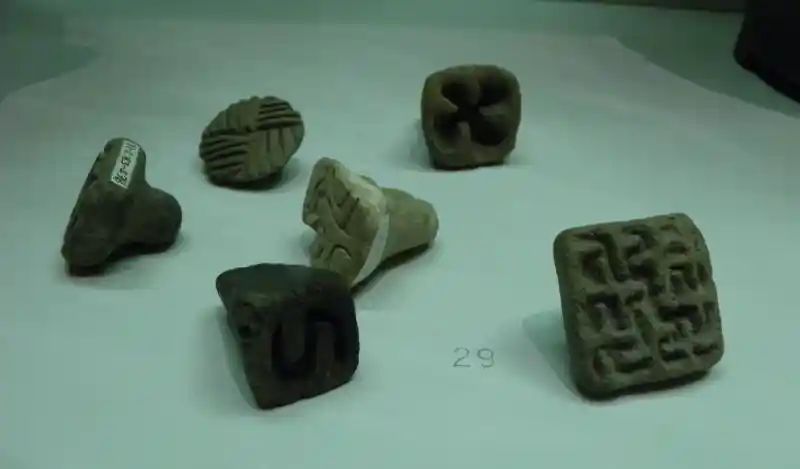 A cross resembling a rounded swastika engraved on a stone